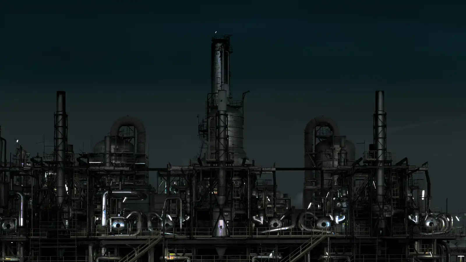 Chimeneas y estructuras de una planta industrial iluminadas durante la noche